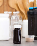 Amber Plastic Wide Mouth Packer Bottle with Child Resistant White Push and Turn Lid - 5 oz / 150 ml